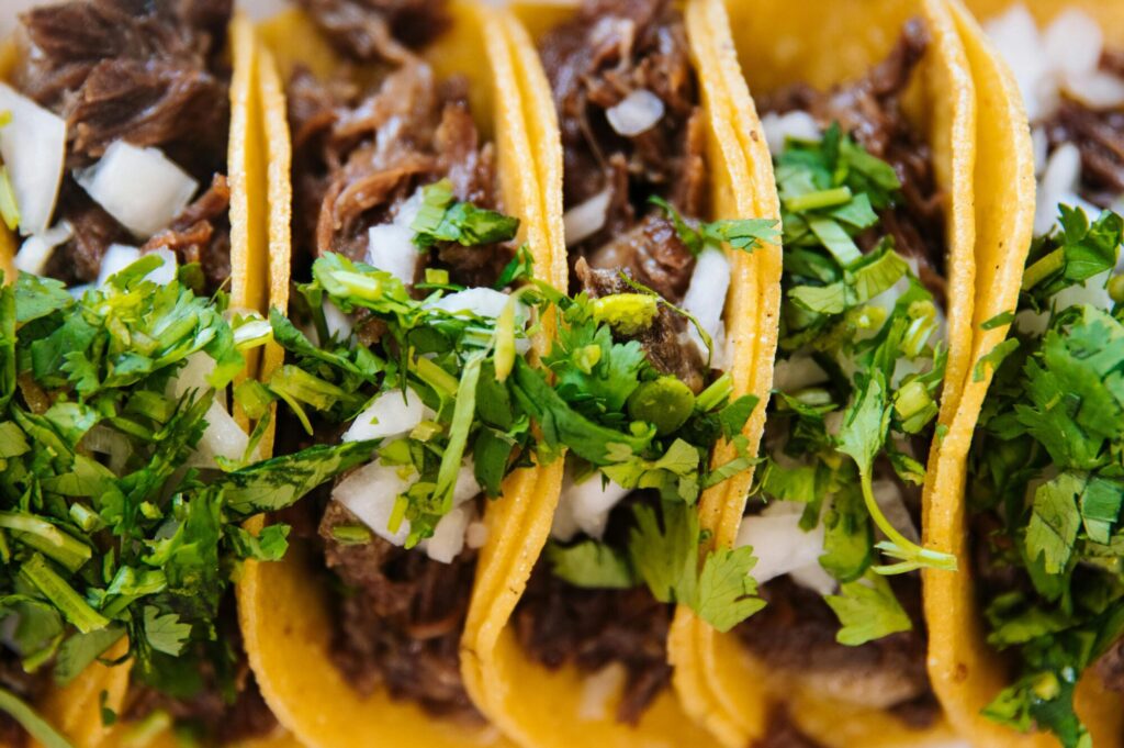 Des tacos authentiques à la viande grillée (carne asada) avec des oignons et de la coriandre