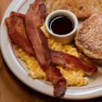 petit déjeuner typique américain avec pancakes, bacon, œufs brouillés, sirop d'érable