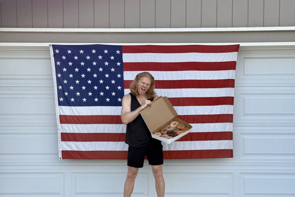 Teiki devant un drapeau américain et des donuts